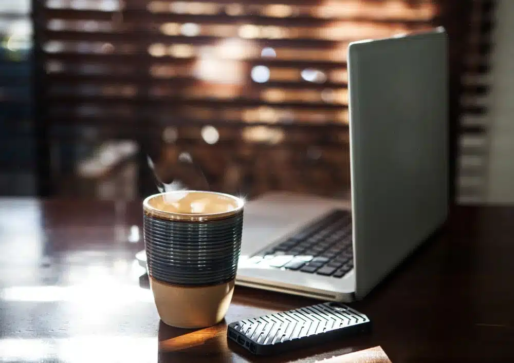 A Cup Of Coffee Beside A Laptop In College