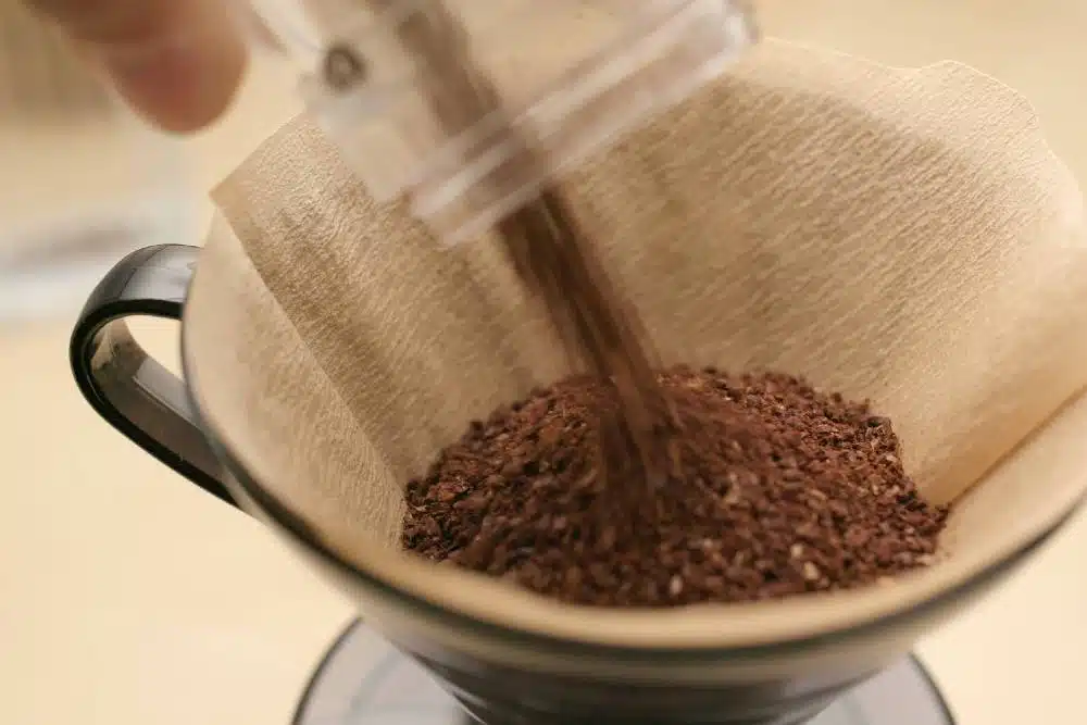 Pouring Some Coffee Into A Brown Paper Filter