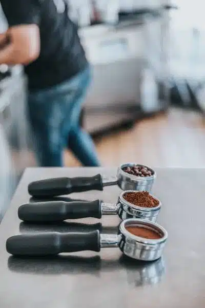 Coffee beans grounds and tamped in portafilters