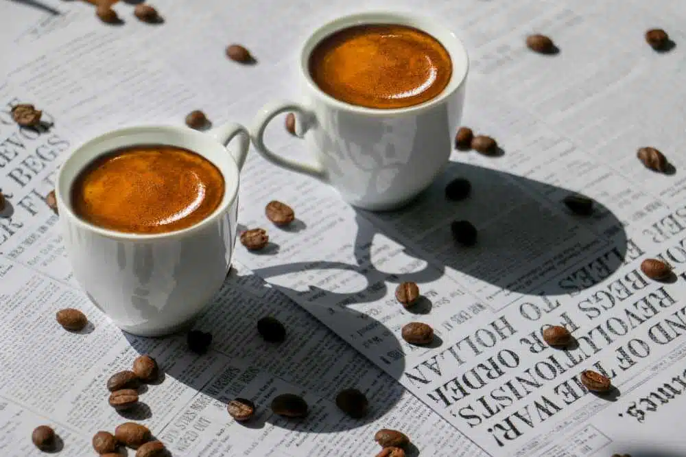 A couple of espresso coffees sitting on a table