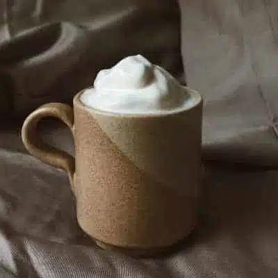 whipped milk in a mug of coffee