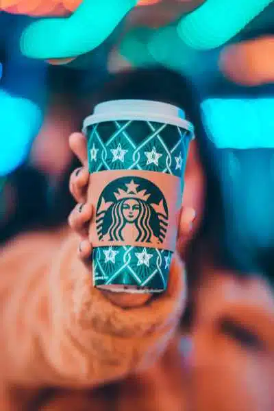 A lady holding a starbucks christmas cup