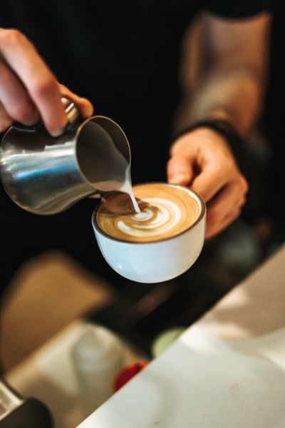 A barista pouring a cappuccino