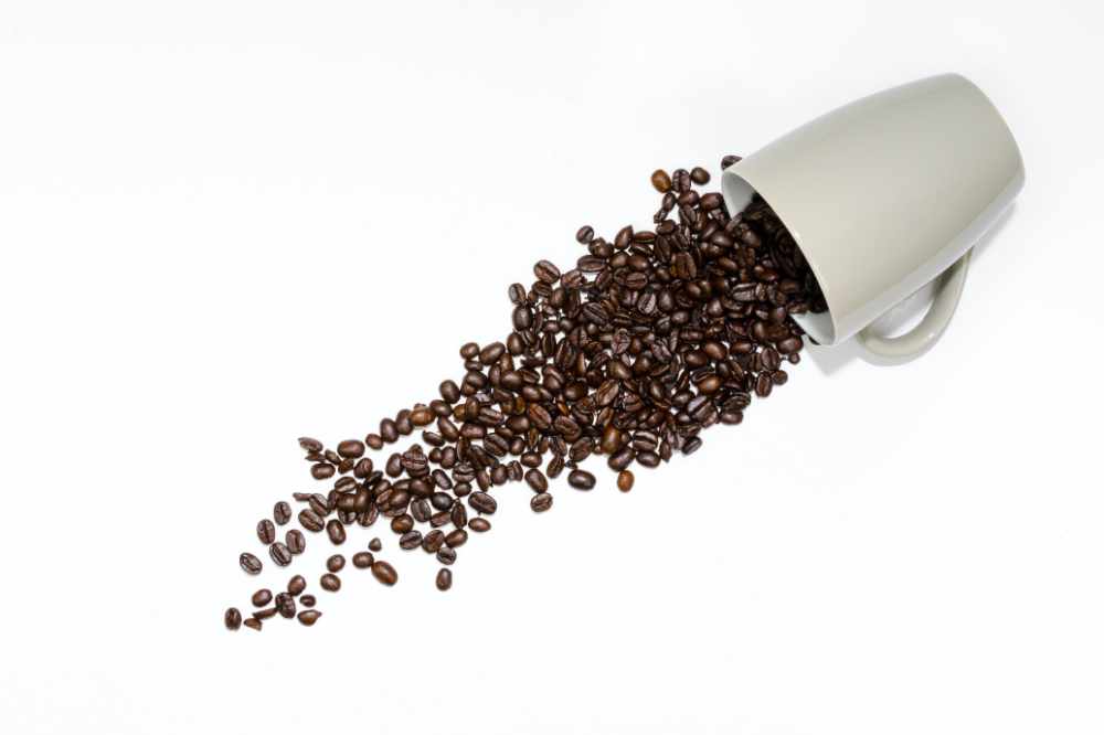 Some Coffee Beans Spilling Out Of A Cup
