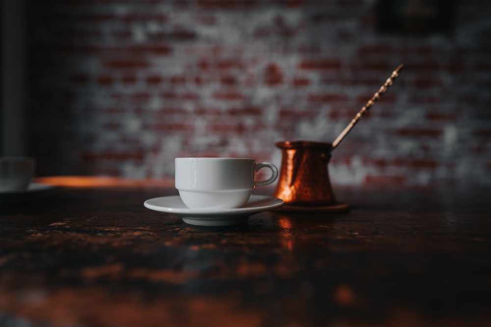 A Cup of Turkish Coffee sat Beside a Cezve