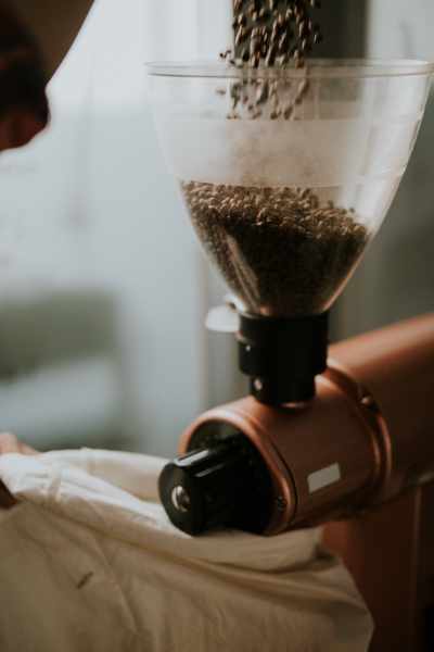 A burr grinder grinding up lots of coffee beans