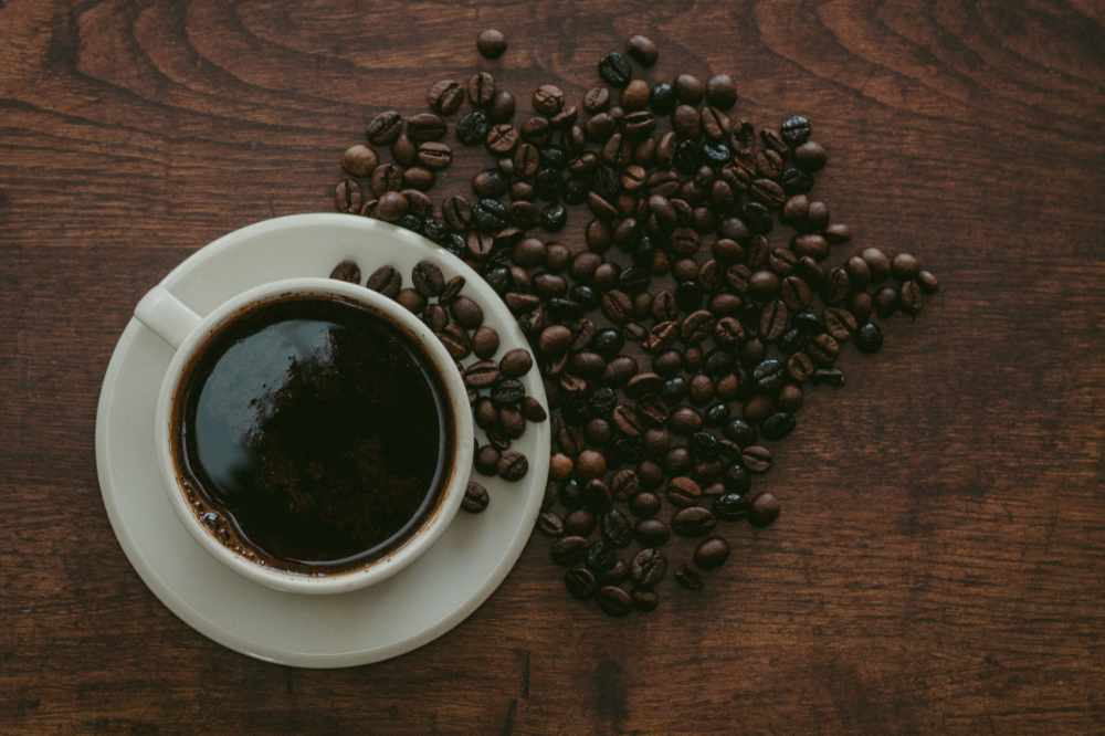 A black coffee and some coffee beans