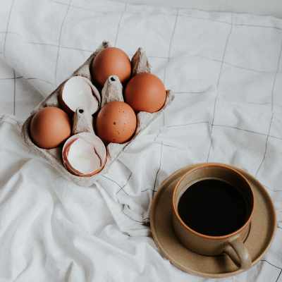 some eggshells beside a cup of coffee