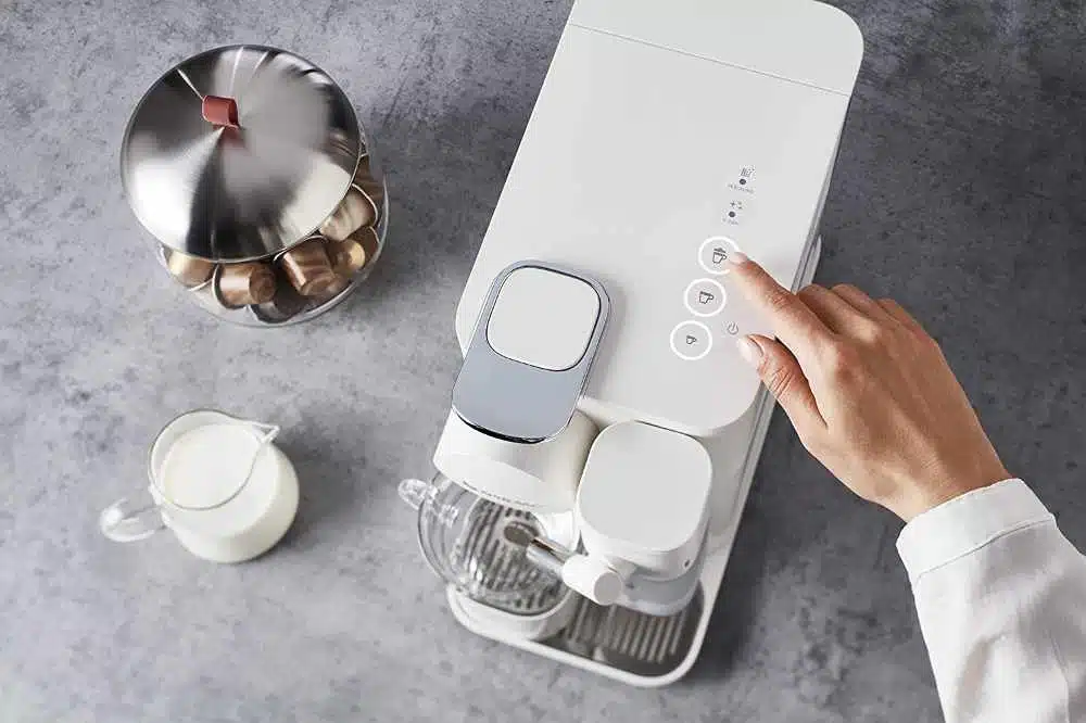 A white nespresso lattissima coffee machine being used from above