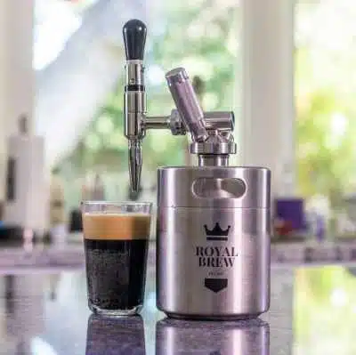 a royal brew nitro keg with a glass of nitro brew beside it