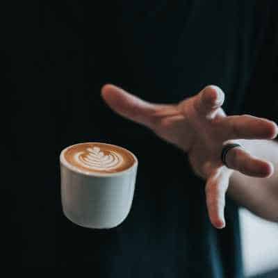 A hand letting go of a piccolo coffee really quickly