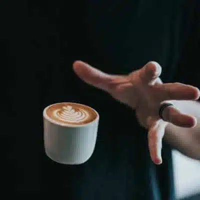 A hand letting go of a piccolo coffee really quickly