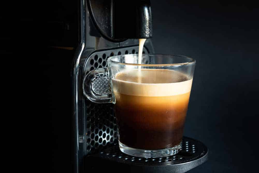 Some hot coffee being poured from a nespresso machine