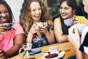 some women having a good laugh over some coffee