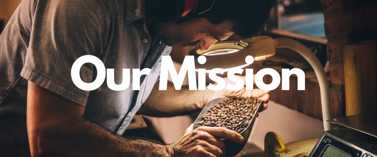 Image of guy wearing ear protection while inspecting coffee beans under a magnifying glass with "Our Mission" written over it in white text. 
